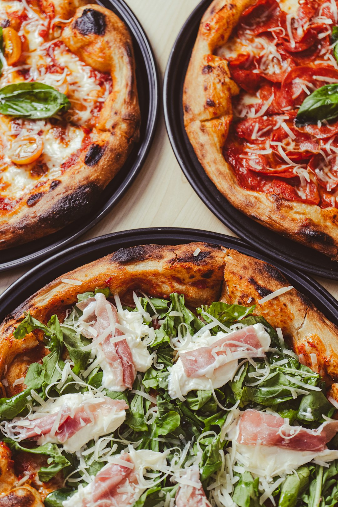 our-story-02 three-pizzas-with-different-toppings-sitting-on-a-table-gechk9mmjzq